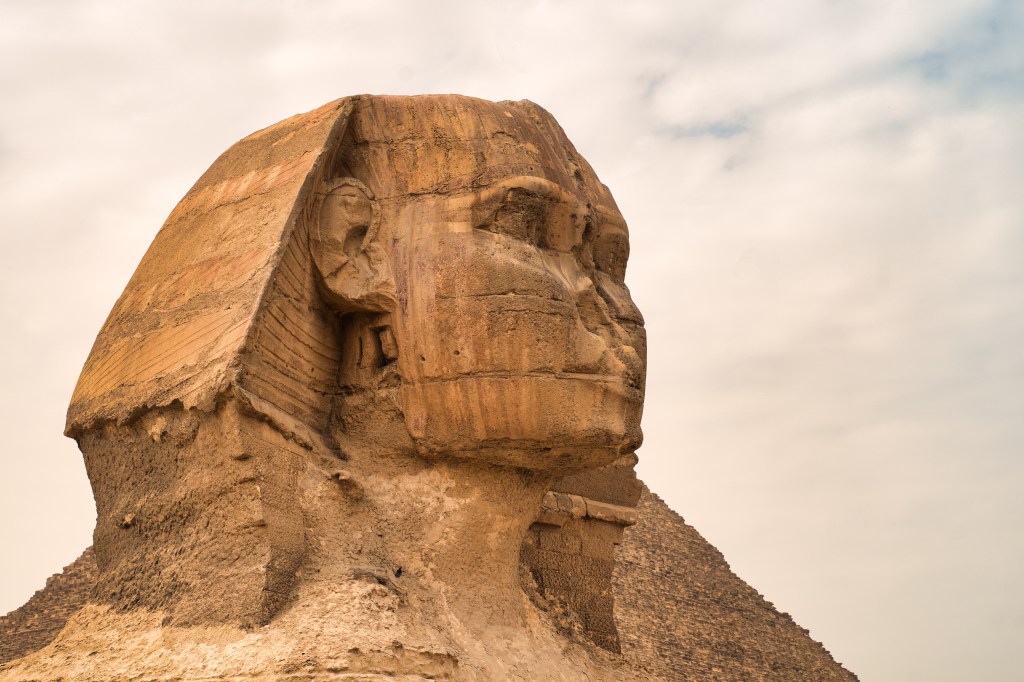 A close view of the weathered head and shoulders of the Sphinx.