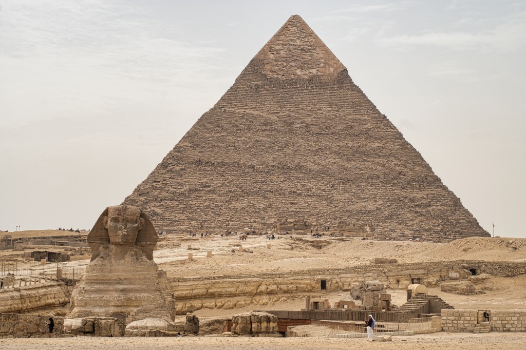 The Great Sphinx in the foreground with a large pyramid rising behind it.